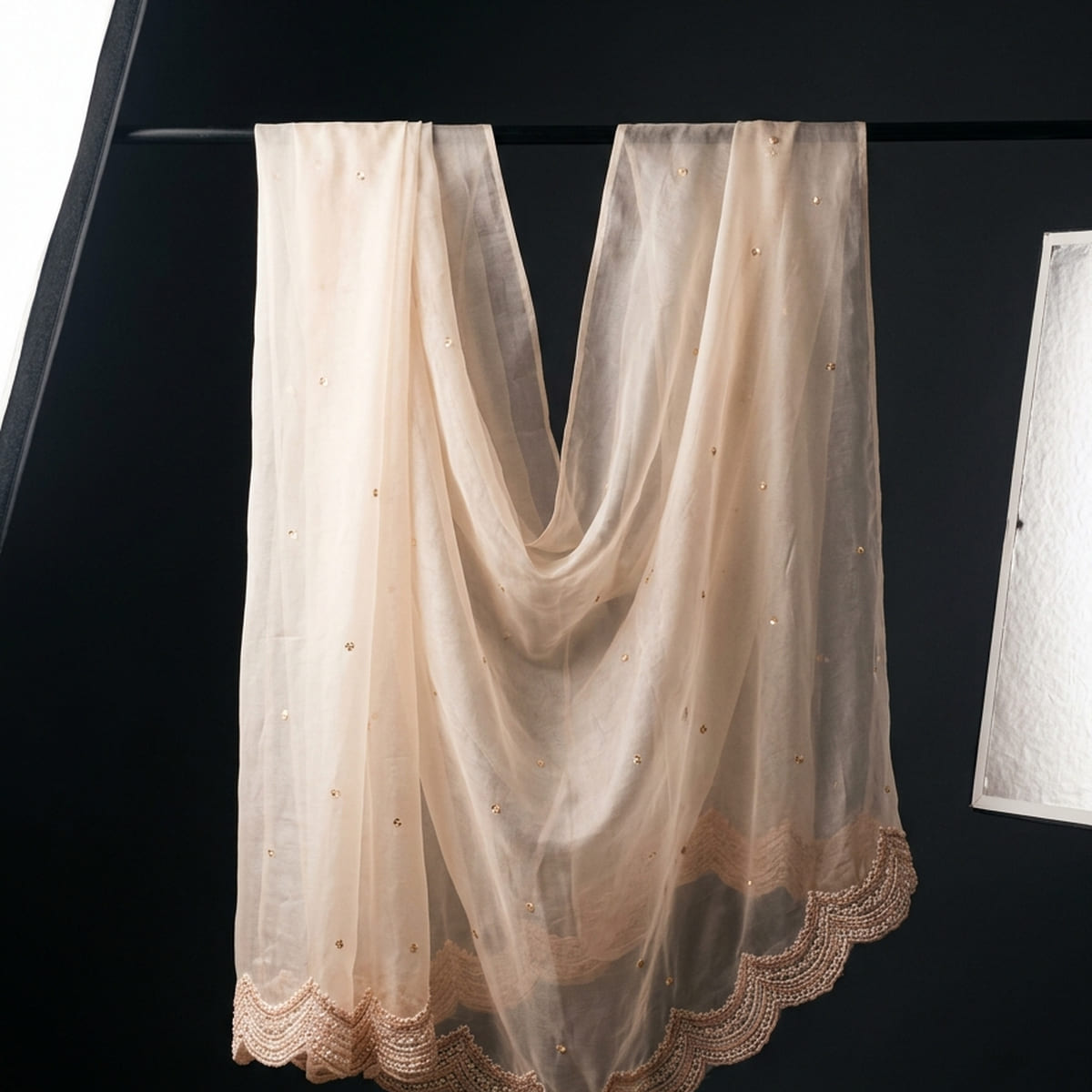 Embroidered silk stretched across a backlit inspection table revealing stitch structure